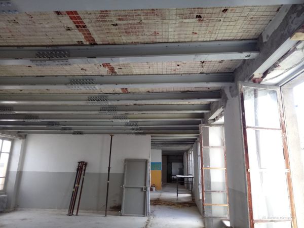 Intervento di consolidamento del solaio mediante posa di travi e profili metallici all’interno dell’edificio.
