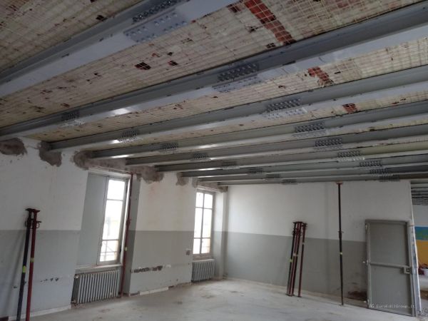Intervento di consolidamento del solaio mediante posa di travi e profili metallici all’interno dell’edificio.