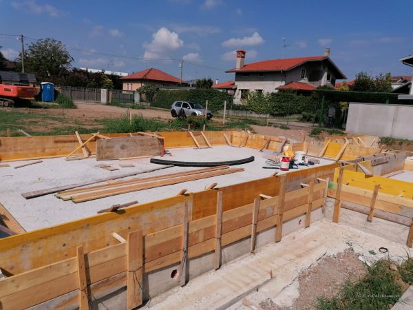 Cantiere edile durante la realizzazione delle fondazioni, con casserature in legno predisposte per il getto del calcestruzzo.