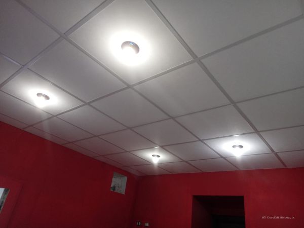 Controsoffitto modulare a pannelli con illuminazione integrata, realizzato all’interno di un locale commerciale.