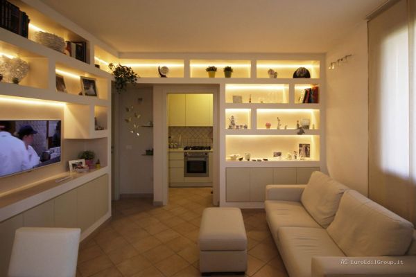 Soggiorno ristrutturato con parete attrezzata in cartongesso, nicchie illuminate a LED e mobile TV integrato.