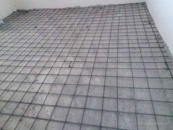 Posa della rete elettrosaldata sul solaio prima della realizzazione del nuovo massetto cementizio.