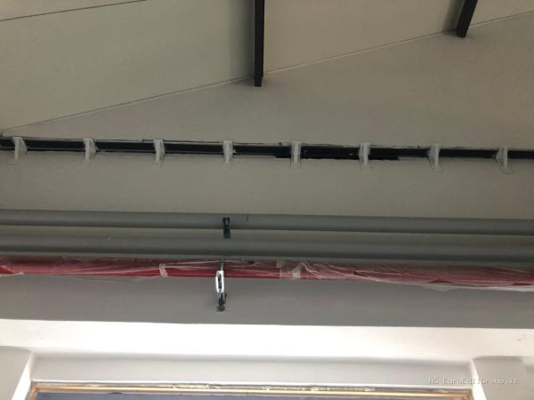 Installazione di tubazioni e canalizzazioni a soffitto durante i lavori di ristrutturazione di un locale.